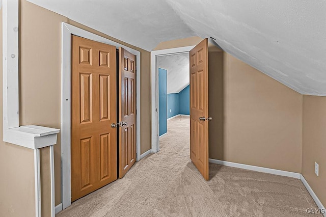 additional living space featuring lofted ceiling and light carpet