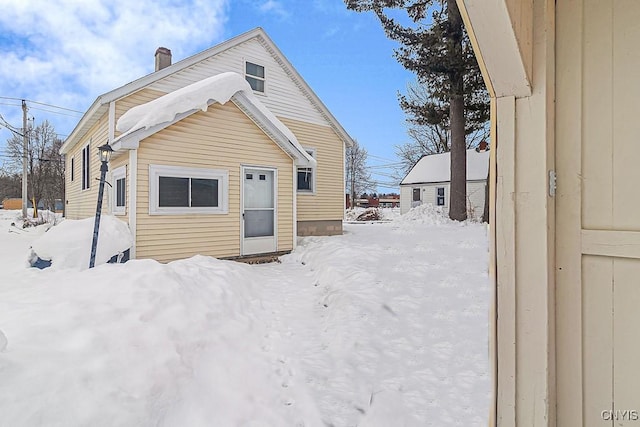 view of snow covered back of property