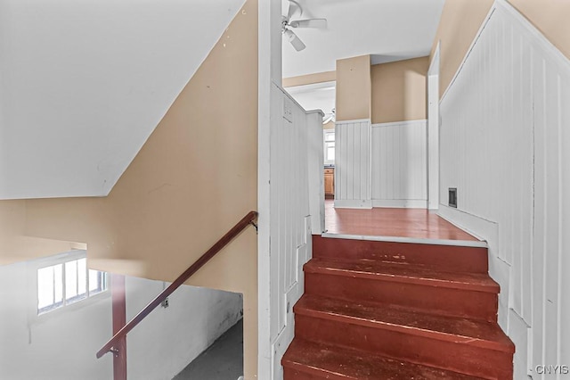 stairway featuring vaulted ceiling and ceiling fan