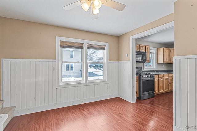 kitchen with ceiling fan, stainless steel range with gas cooktop, dark hardwood / wood-style floors, and light brown cabinetry