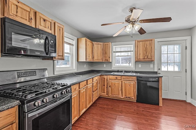 kitchen featuring plenty of natural light, dark wood-type flooring, and black appliances