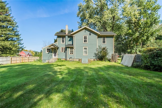 rear view of property featuring a lawn