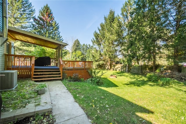 view of yard featuring cooling unit and a deck