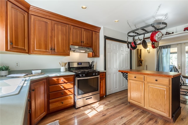 kitchen with french doors, stainless steel gas range oven, and light hardwood / wood-style flooring