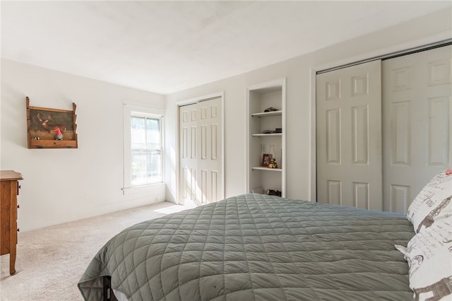 carpeted bedroom featuring multiple closets