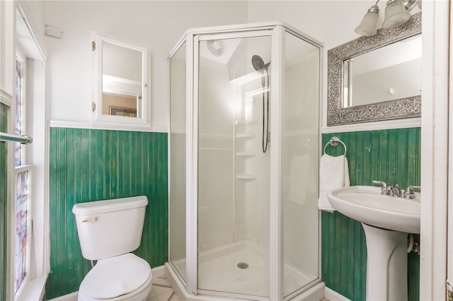 bathroom featuring sink, toilet, a shower with shower door, and tile patterned flooring