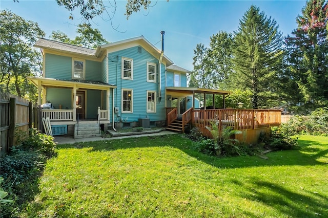 rear view of property with a wooden deck, a yard, and central AC