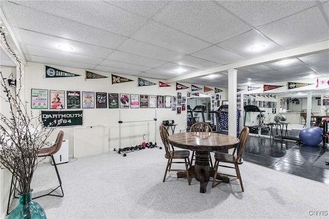 carpeted dining room with a drop ceiling