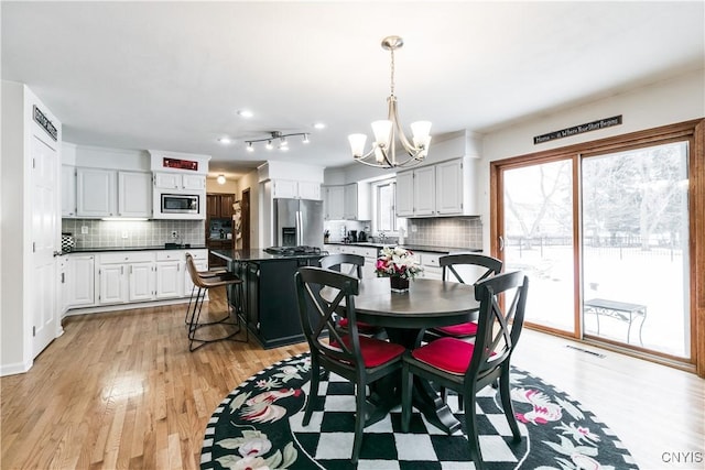 dining area featuring light hardwood / wood-style flooring and a chandelier