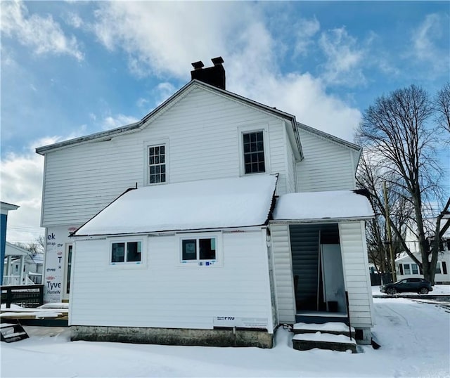 view of snow covered rear of property