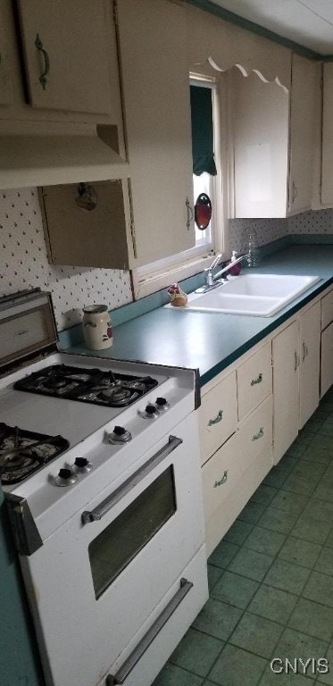 kitchen with sink, decorative backsplash, and gas range gas stove