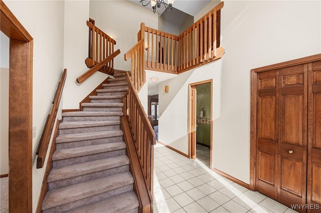 stairs featuring a towering ceiling and tile patterned floors