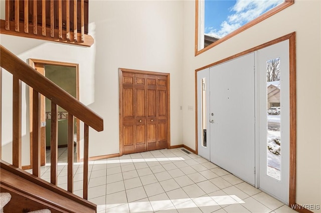 entryway featuring light tile patterned flooring and a high ceiling