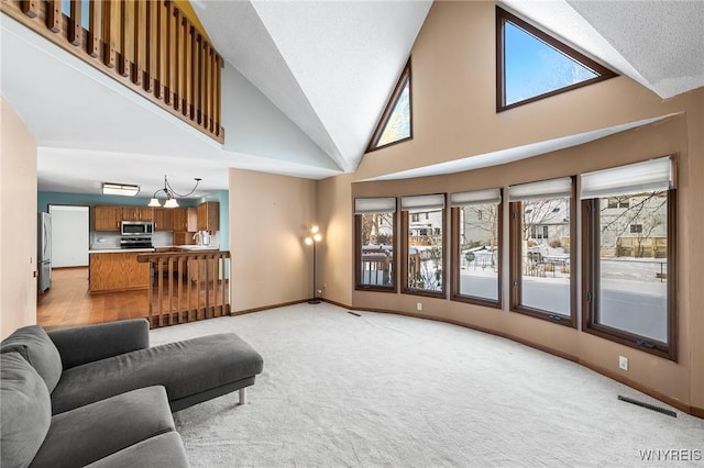 carpeted living room featuring sink and high vaulted ceiling