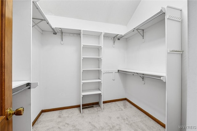 walk in closet featuring light colored carpet