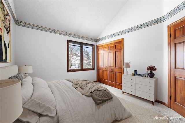 bedroom featuring light carpet, lofted ceiling, a closet, and a textured ceiling