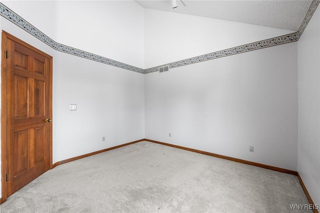 unfurnished room featuring lofted ceiling and light carpet