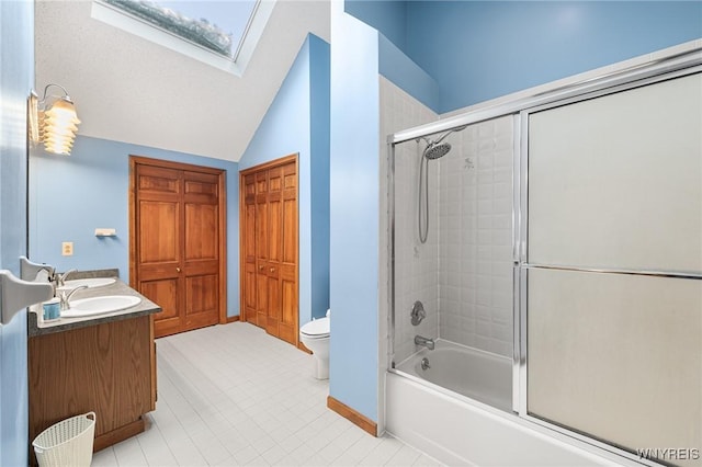 full bathroom featuring enclosed tub / shower combo, lofted ceiling with skylight, vanity, and toilet