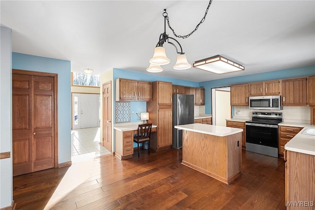 kitchen with a kitchen island, pendant lighting, decorative backsplash, stainless steel appliances, and dark wood-type flooring