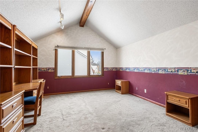 unfurnished office with built in desk, light carpet, a textured ceiling, and vaulted ceiling with beams