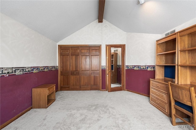 carpeted bedroom featuring vaulted ceiling with beams, a textured ceiling, and a closet