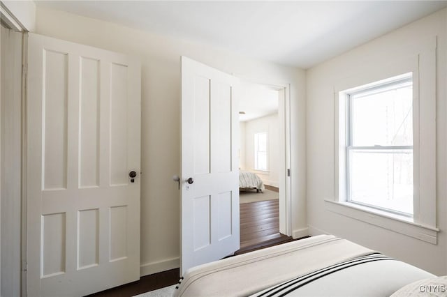 bedroom featuring wood finished floors and baseboards