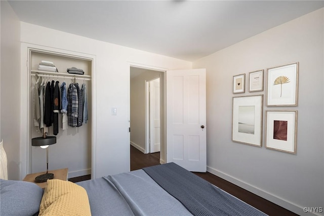 bedroom featuring dark wood-style floors, a closet, and baseboards