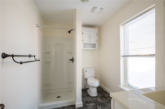 bathroom featuring plenty of natural light, toilet, vanity, and a shower