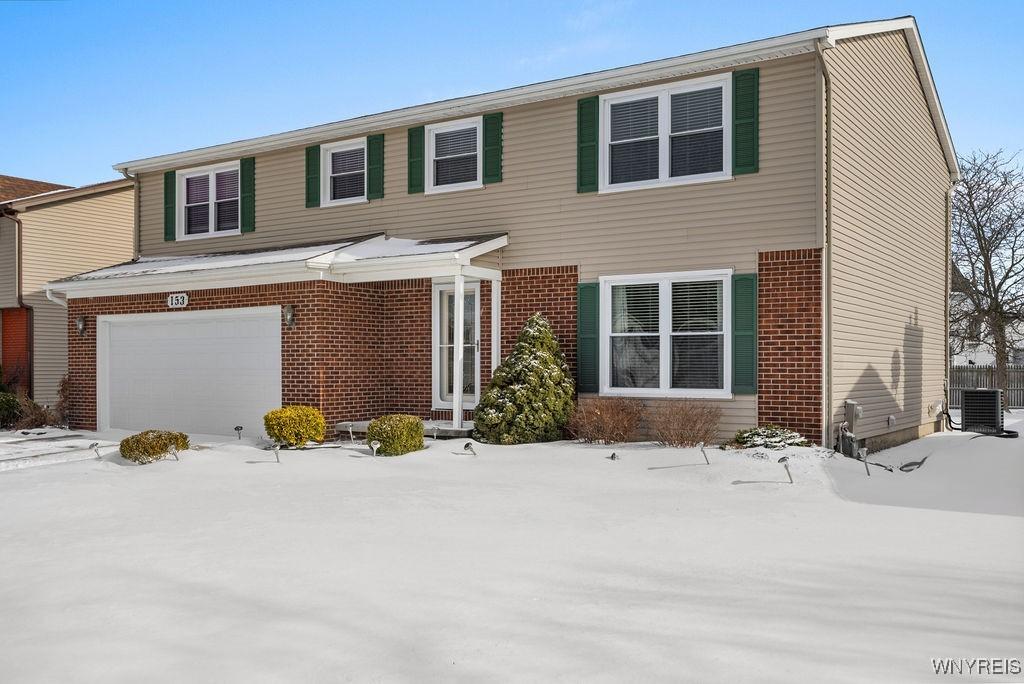 view of front of house with a garage and central AC