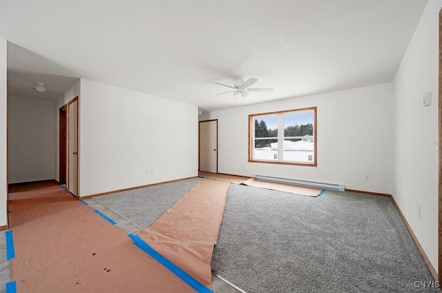 carpeted spare room featuring baseboard heating and ceiling fan