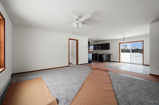 unfurnished living room featuring ceiling fan with notable chandelier and a baseboard radiator