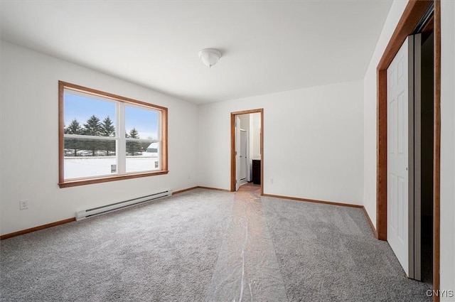 unfurnished bedroom with a baseboard heating unit, ensuite bath, and carpet flooring