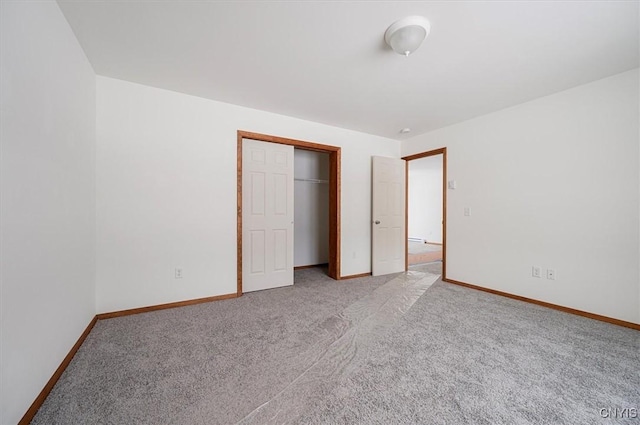 unfurnished bedroom featuring light carpet and a closet