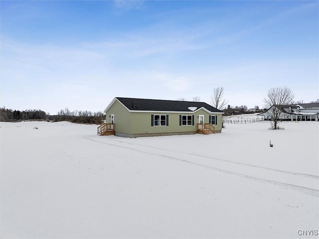 view of snow covered rear of property