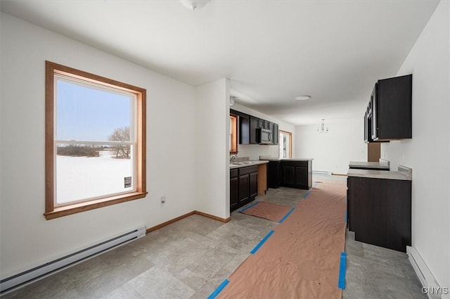 kitchen featuring an inviting chandelier, a baseboard heating unit, and sink