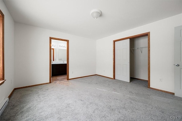 unfurnished bedroom with baseboard heating, ensuite bath, light colored carpet, and a closet