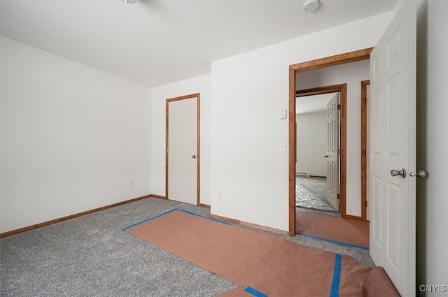 unfurnished bedroom with carpet and a baseboard heating unit