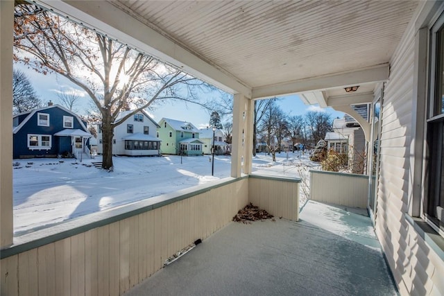 snow covered patio featuring covered porch