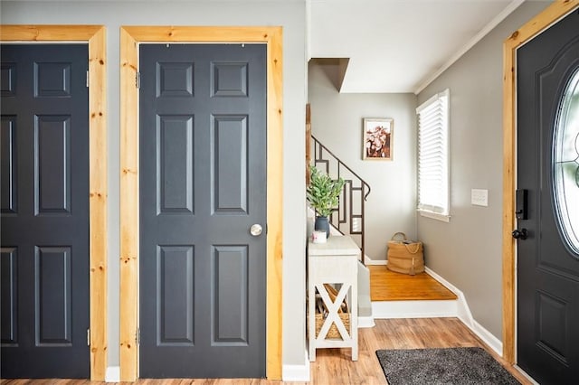 entryway featuring crown molding and light wood-type flooring