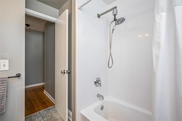 bathroom with wood-type flooring and shower / bathtub combination with curtain