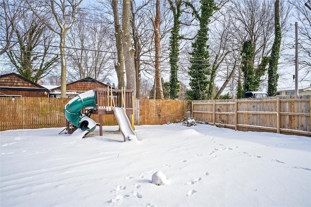 yard layered in snow featuring a playground