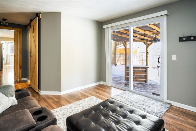 living room with wood-type flooring and a barn door