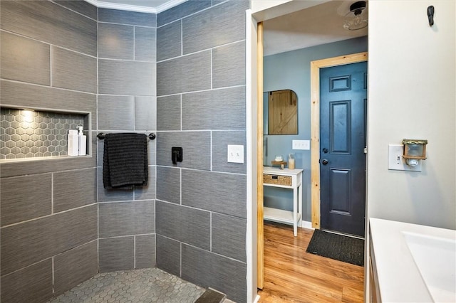 bathroom featuring tiled shower, wood-type flooring, and vanity