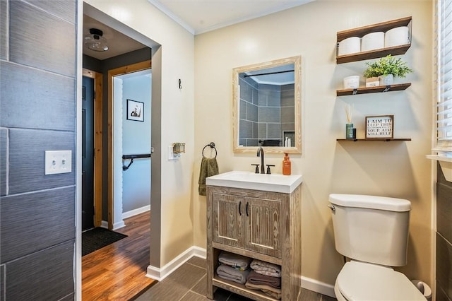 bathroom with vanity, hardwood / wood-style flooring, ornamental molding, and toilet