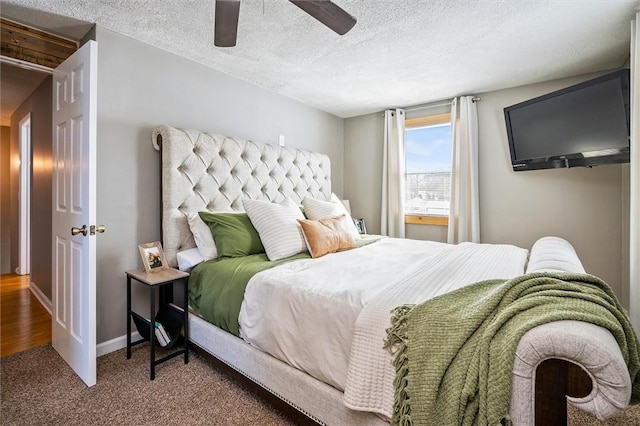 carpeted bedroom featuring ceiling fan and a textured ceiling