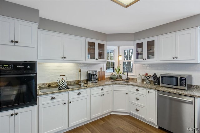 kitchen featuring sink, stone counters, white cabinetry, black appliances, and dark hardwood / wood-style flooring