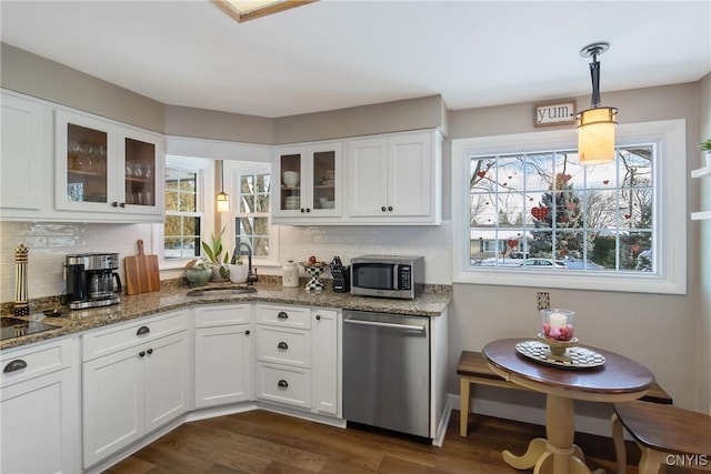 kitchen featuring stone counters, decorative light fixtures, sink, white cabinets, and stainless steel appliances