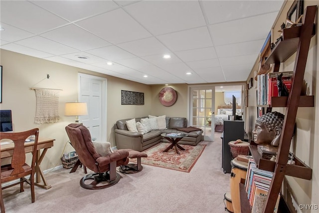 carpeted living room with a paneled ceiling