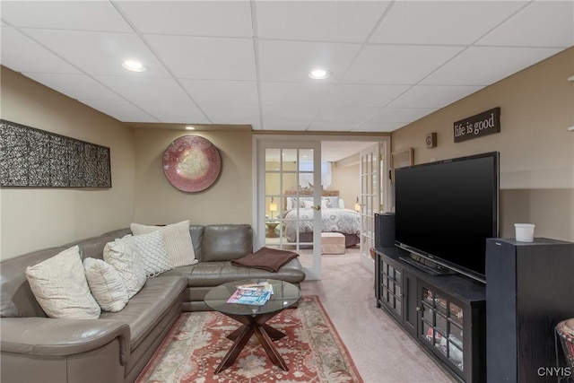 carpeted living room featuring a paneled ceiling and french doors