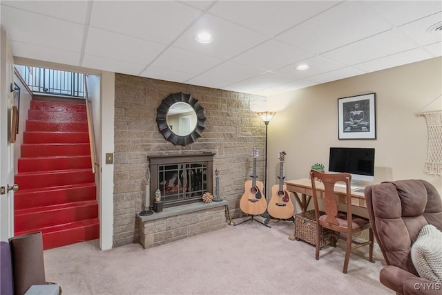 carpeted living room with a large fireplace and a paneled ceiling